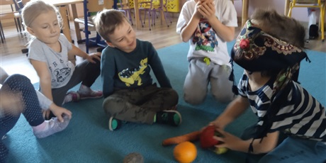 Powiększ grafikę: zabawa doskonaląca zmysł dotyku - Jaki to owoc, dziecko z zasłoniętymi oczami zgaduje jaki owoc ma w ręku