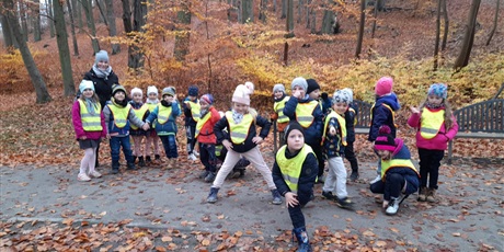 Powiększ grafikę: w drodze powrotnej do przedszkola dzieci pozują do zdjęcia w parku