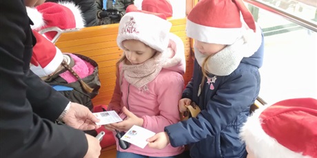 Powiększ grafikę: dziewczynki podają konduktorowi bilet do skasowania