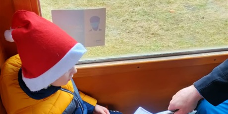 Powiększ grafikę: Chłopiec podaje bilet do skasowania przez konduktora