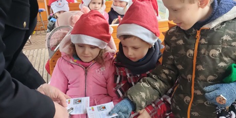 Powiększ grafikę: Dzieci obserwują jak konduktor kasuje bilety