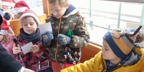 Powiększ grafikę: Dzieci podają bilety do skasowania w tramwaju