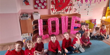 Powiększ grafikę: grupa motylków przy napisie love dzieci ubrane na czerwono