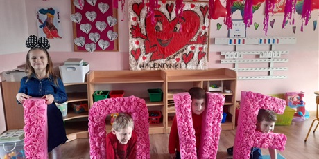 Powiększ grafikę: dzieci trzymaja napis love i uśmiechają sie w nim