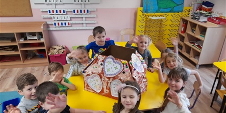 Powiększ grafikę: dzieci z grupy motylki prezentują kartonowy domek z piernika