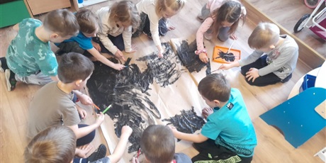 Powiększ grafikę: grupa motylków tworzy obraz z użyciem czarnej farby