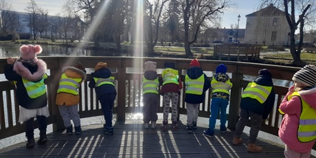 Powiększ grafikę: dzieci obserwują ptaki wodne z pomostu w parku