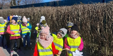 Powiększ grafikę: Grupa Motylków na spacerze z okazji dnia kobiet wręcza wykonane własnoręcznie kwiatki z papieru