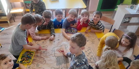 Powiększ grafikę: Dzieci tworzą plakat na dzień kobiet