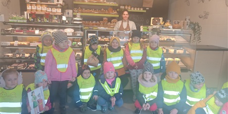 Powiększ grafikę: Dzieci pozują do wspólnego zdjęcia w piekarni z panią ekspedientką