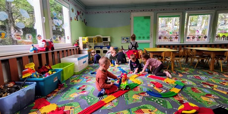 Powiększ grafikę: dzieci budują tory i wspólnie się bawią