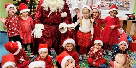 Powiększ grafikę: Mikołaj w przedszkolu - wspólne zdjęcia z Mikołajem i p. Dyrektor, dzieci są ubrane na czerwono i maja mikołajowe czaapeczki