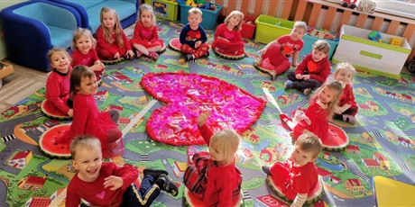 Powiększ grafikę: Dzieci siedzą w kręgu wokół serca i opowiadają o tym, komu chciały by je dać