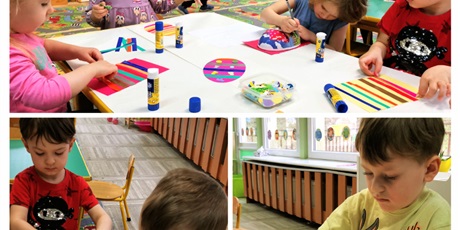 Powiększ grafikę: Dzieci wykonują pracę plastyczną - wielkanocne kolorowe jajko w paski zdobione wybranymi naklejkami